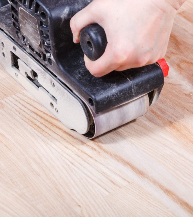 finishing ashwood surface by hand-held belt sander